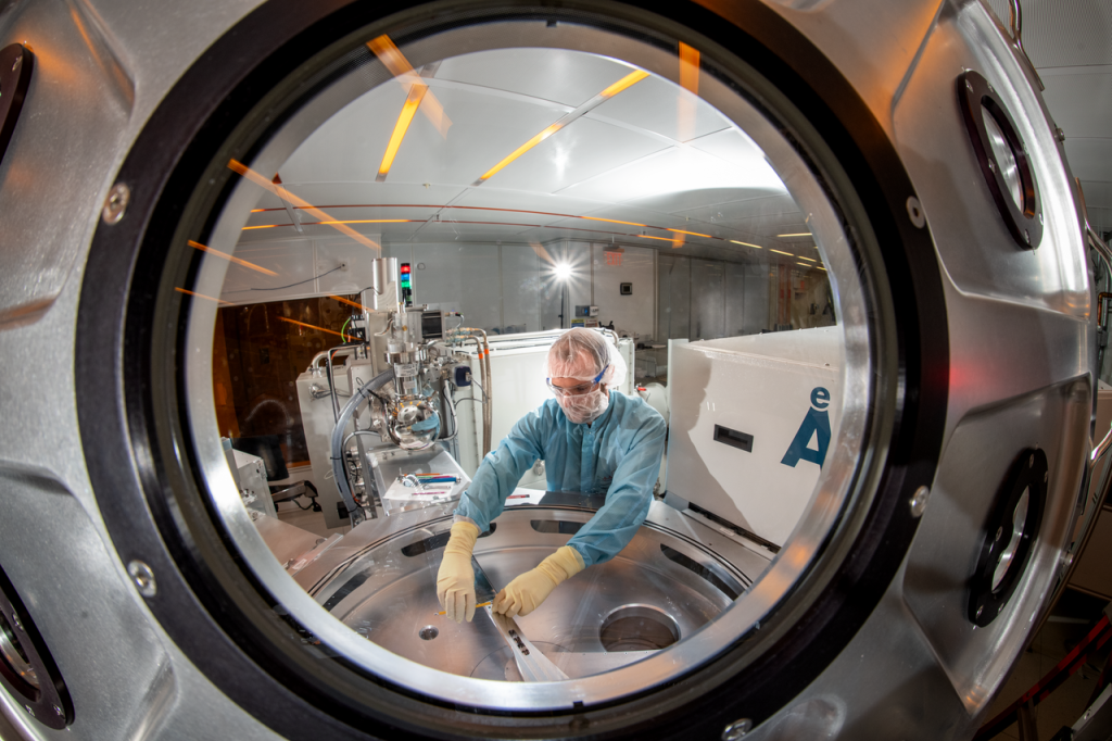 Arian Gashi, Senior Scientific Engineering Associate, Molecular Foundry, calibrates the robot transfer station of the Cluster Deposition Tool in the cleanroom at the Molecular Foundry, Lawrence Berkeley National Laboratory.