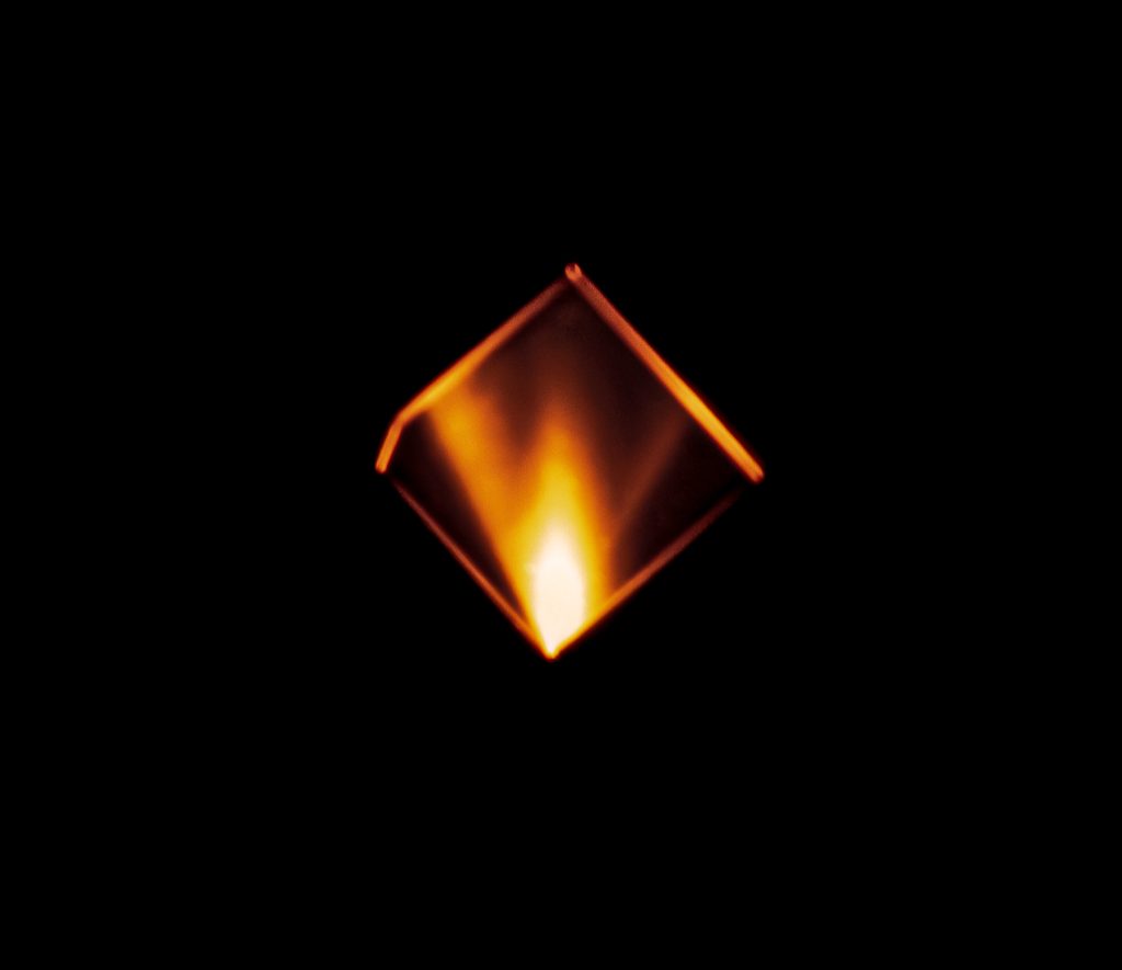 A close-up image of a diamond sample undergoing fluorescence.